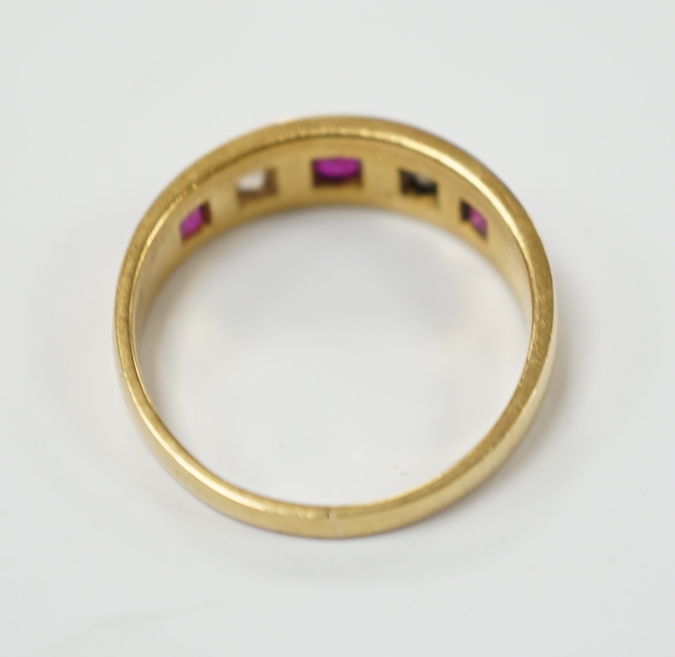 An early 20th century yellow metal ruby and diamond set five stone dress ring, size P